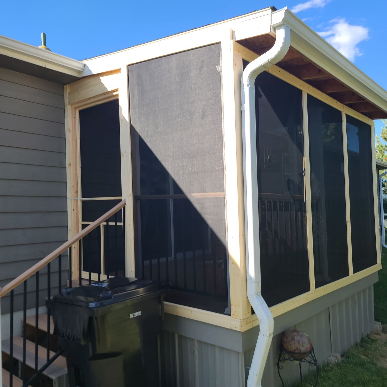 Newly framed and screened porch addition, corner view with gutter and downspout