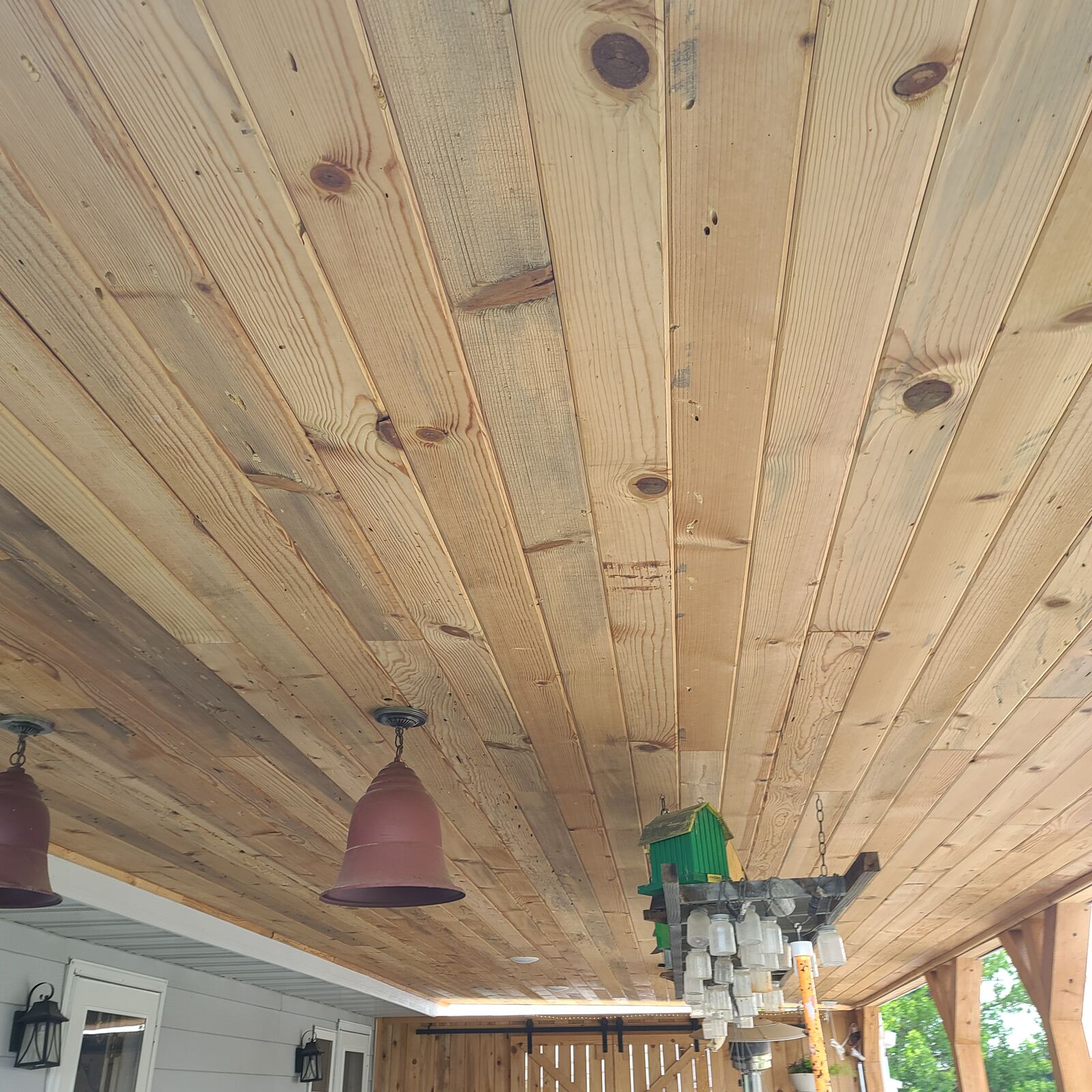 Tongue and groove wood porch ceiling with pendant lighting
